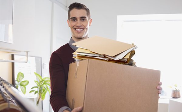 Person carrying a box full of documents